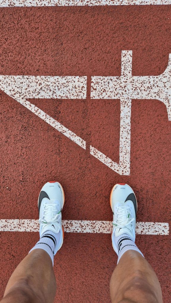Top view of runner's shoes at the starting line on a running track, ready to race.